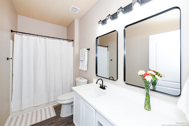 bathroom with wood-type flooring, toilet, and vanity