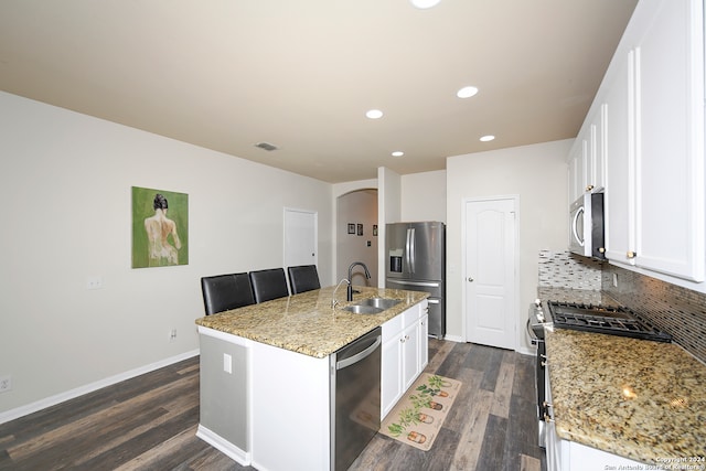 kitchen with a kitchen island with sink, dark hardwood / wood-style floors, appliances with stainless steel finishes, sink, and tasteful backsplash