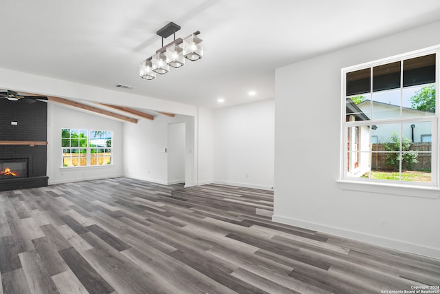 unfurnished living room with a healthy amount of sunlight and dark wood-type flooring