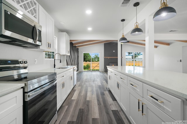 kitchen featuring appliances with stainless steel finishes, lofted ceiling with beams, sink, dark wood-type flooring, and decorative light fixtures