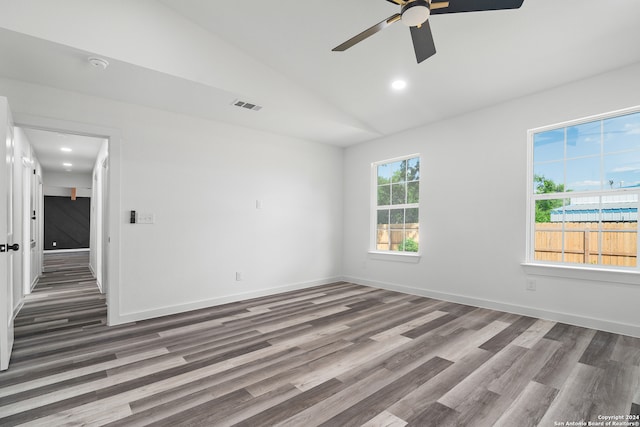 unfurnished room featuring vaulted ceiling, plenty of natural light, ceiling fan, and dark wood-type flooring