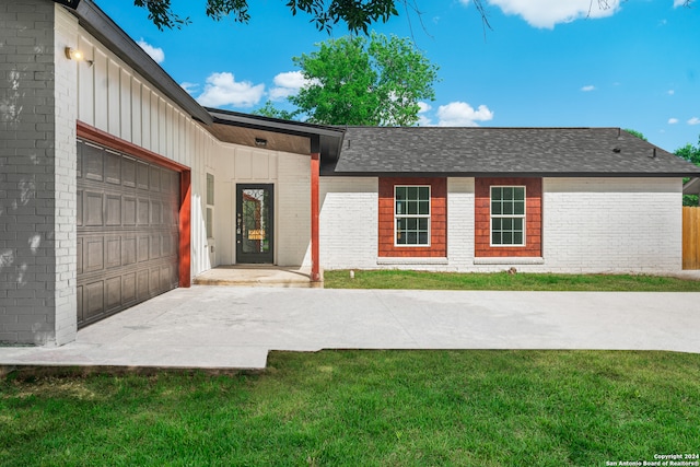 ranch-style house featuring a garage and a front yard