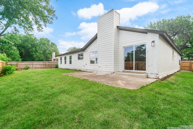 rear view of house featuring a yard and a patio area