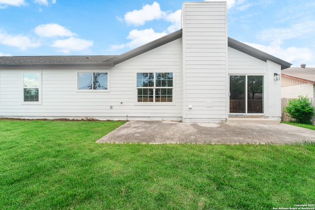 rear view of house featuring a lawn and a patio area