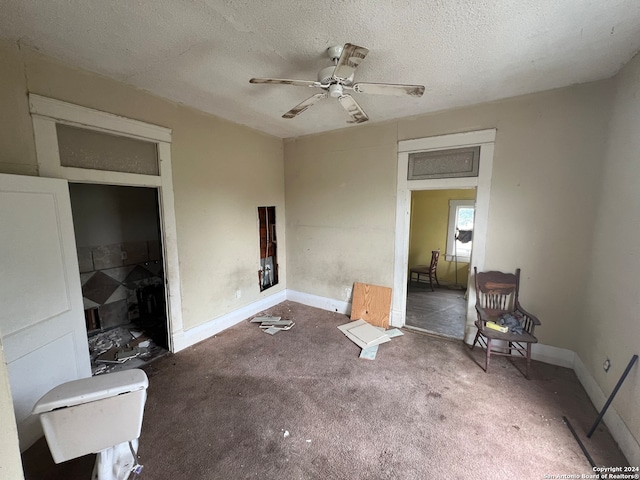 carpeted bedroom with a closet, a textured ceiling, and ceiling fan