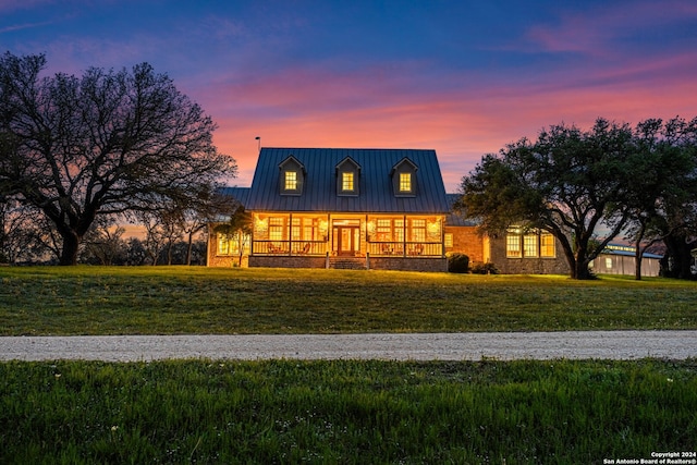 cape cod house featuring a yard