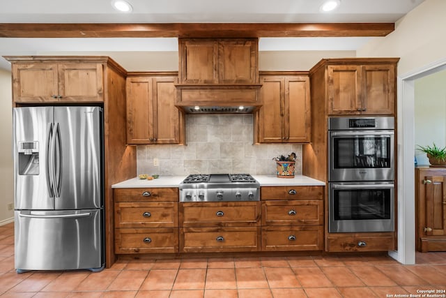 kitchen featuring appliances with stainless steel finishes, tasteful backsplash, custom exhaust hood, and light tile floors