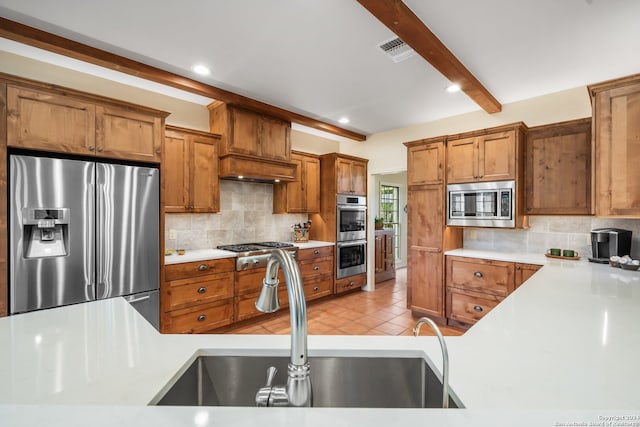 kitchen featuring backsplash, stainless steel appliances, light tile floors, and beam ceiling