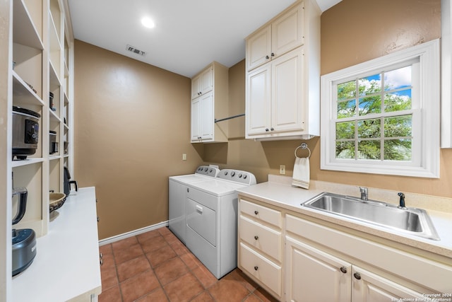 laundry room with sink, cabinets, tile floors, and washing machine and clothes dryer