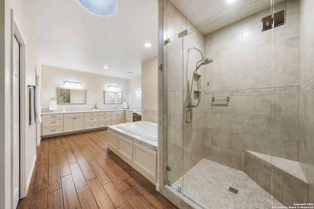 bathroom featuring hardwood / wood-style floors, dual vanity, and shower with separate bathtub