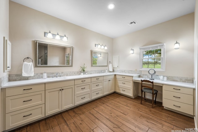 bathroom featuring backsplash, dual bowl vanity, and hardwood / wood-style floors