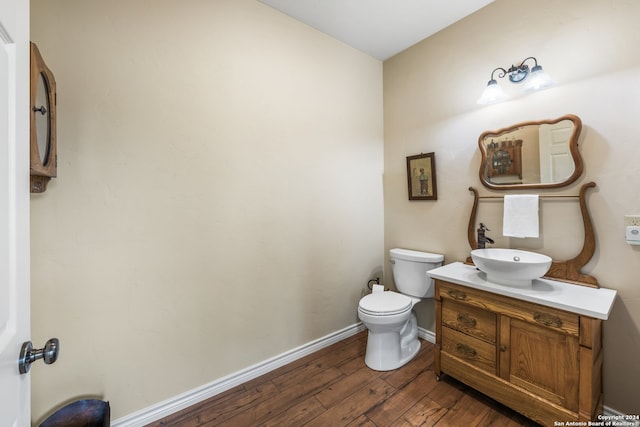 bathroom with vanity with extensive cabinet space, toilet, and hardwood / wood-style flooring