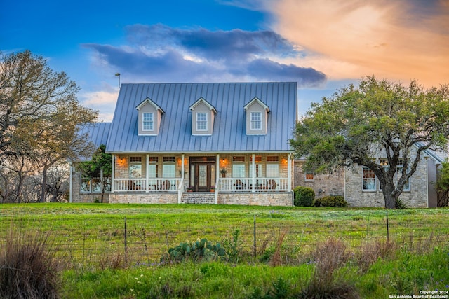 view of front of property featuring a lawn and a porch