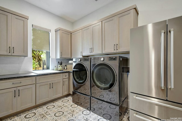 clothes washing area featuring light tile patterned floors, washing machine and clothes dryer, and sink