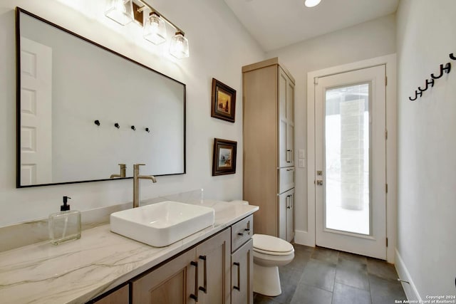 bathroom featuring toilet, a wealth of natural light, and vanity