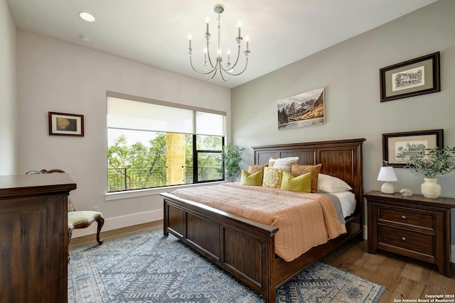 bedroom with light hardwood / wood-style flooring and a notable chandelier