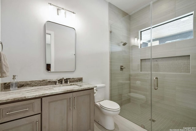 bathroom featuring toilet, vanity, and an enclosed shower