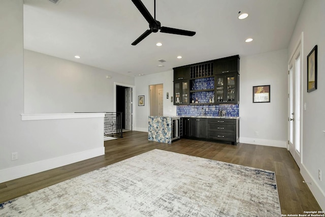 interior space with ceiling fan, backsplash, dark hardwood / wood-style flooring, beverage cooler, and light stone counters