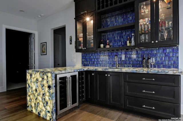 bar with dark hardwood / wood-style flooring, decorative backsplash, wine cooler, and sink