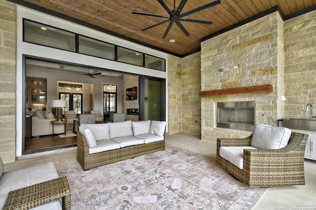 view of patio / terrace featuring ceiling fan and an outdoor living space with a fireplace