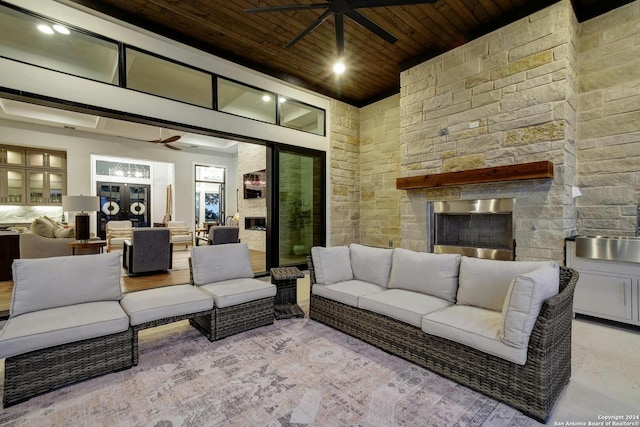 interior space featuring wooden ceiling, a fireplace, a high ceiling, and ceiling fan