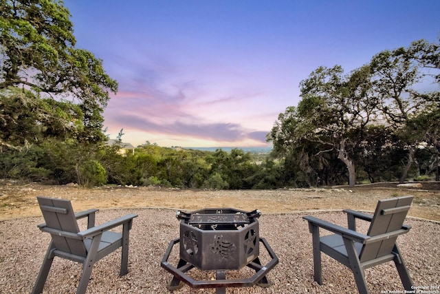 yard at dusk featuring an outdoor fire pit