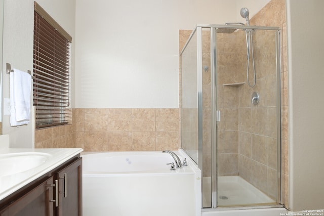 bathroom featuring vanity and shower with separate bathtub