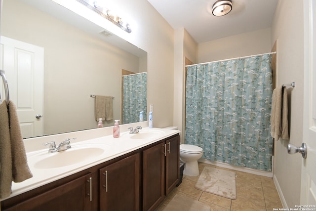 bathroom with toilet, tile floors, and double sink vanity