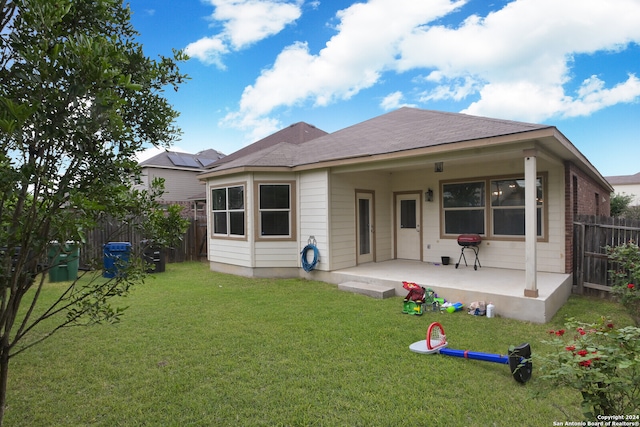 back of property with a patio area and a lawn