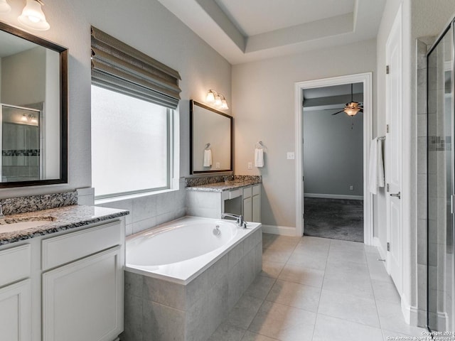 bathroom featuring dual bowl vanity, tile flooring, a raised ceiling, ceiling fan, and tiled bath