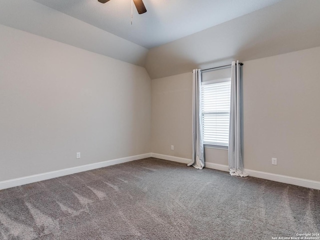 carpeted spare room with ceiling fan and lofted ceiling