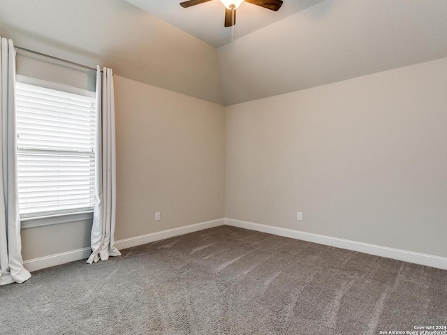 spare room with vaulted ceiling, ceiling fan, and carpet flooring