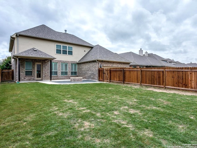 rear view of property featuring a patio area and a yard