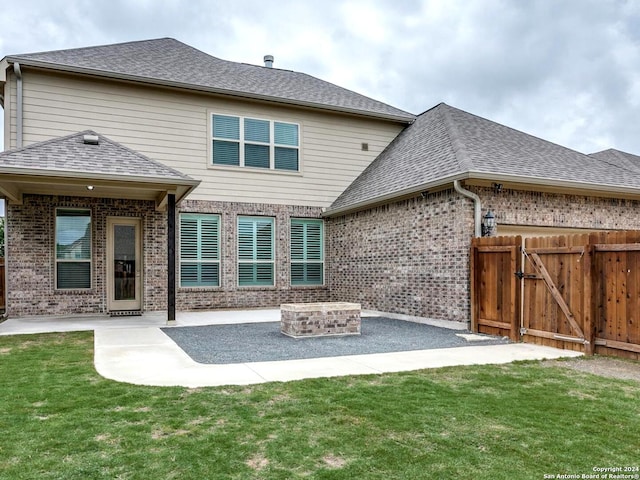 back of house with a yard, an outdoor fire pit, and a patio