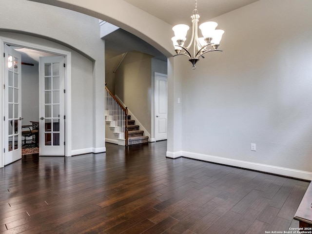 unfurnished room featuring dark hardwood / wood-style flooring, french doors, and a notable chandelier