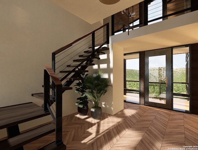 staircase with a towering ceiling and parquet floors