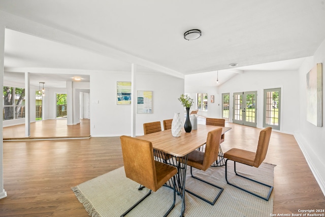 dining area featuring hardwood / wood-style flooring, french doors, and vaulted ceiling