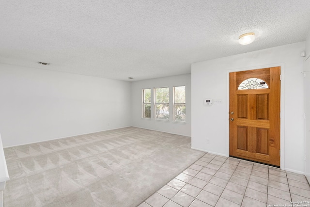 entrance foyer featuring a textured ceiling and light tile patterned floors