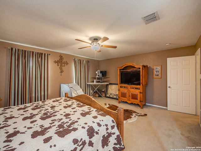 carpeted bedroom with a textured ceiling and ceiling fan