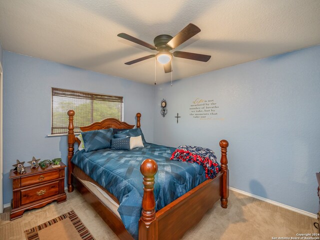 bedroom with light carpet, a textured ceiling, and ceiling fan