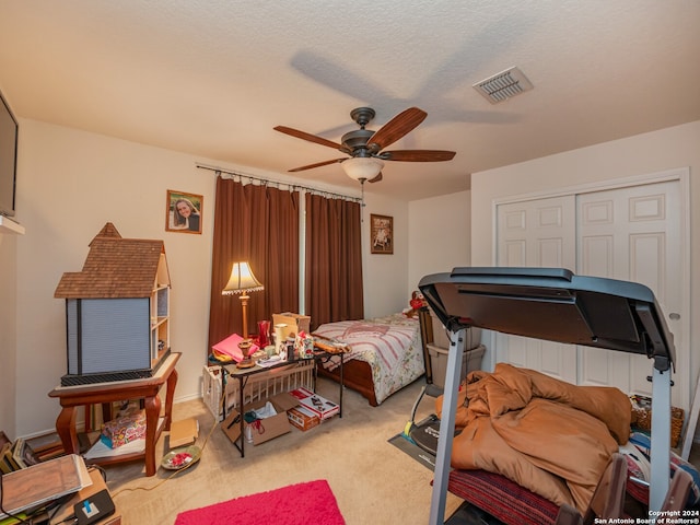 carpeted bedroom featuring ceiling fan, a textured ceiling, and a closet