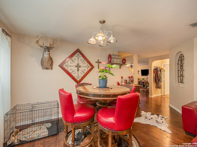 dining area featuring a notable chandelier and dark wood-type flooring