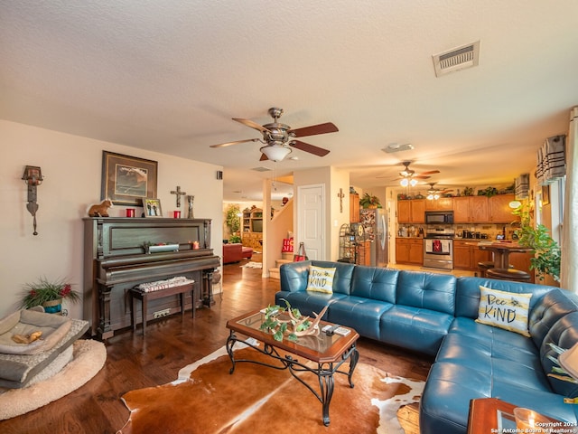 living room with a textured ceiling and dark hardwood / wood-style floors