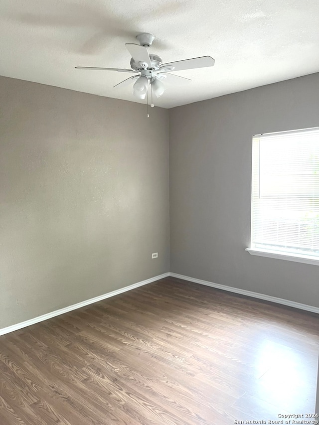 empty room featuring ceiling fan and dark hardwood / wood-style flooring