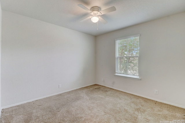 spare room featuring ceiling fan and light colored carpet