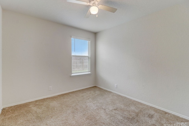 carpeted spare room with ceiling fan