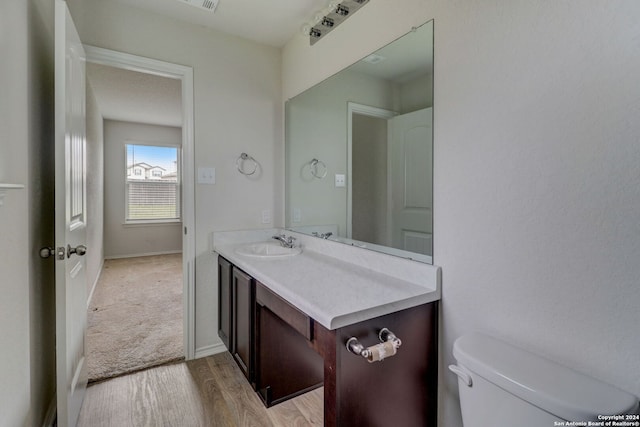 bathroom featuring hardwood / wood-style floors, vanity, and toilet