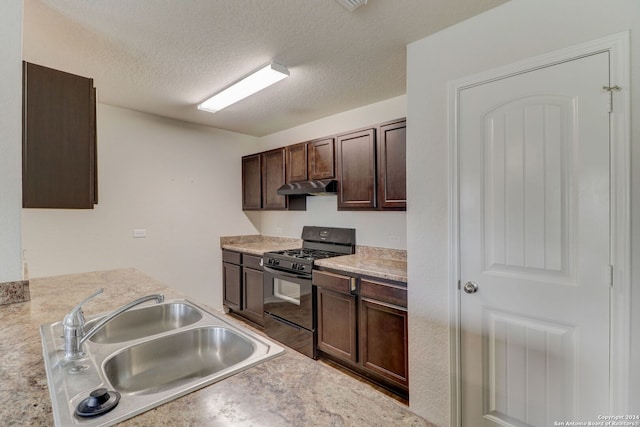 kitchen with gas stove, dark brown cabinets, sink, and a textured ceiling