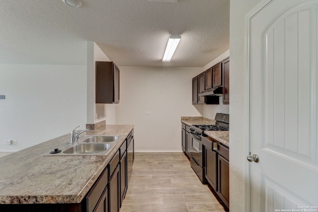 kitchen with a textured ceiling, gas stove, sink, light hardwood / wood-style flooring, and dishwasher