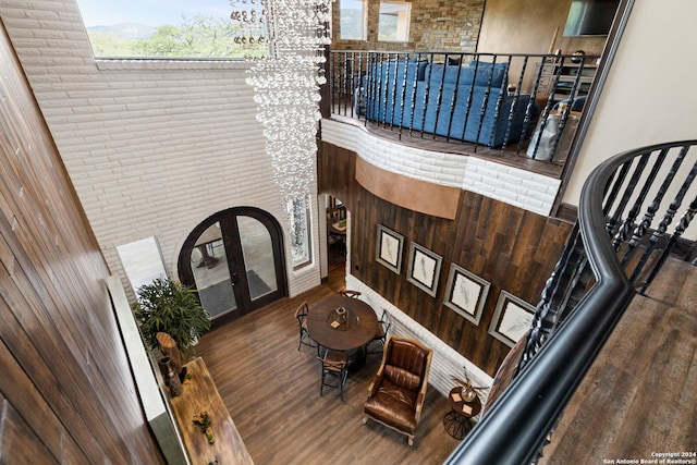 foyer entrance featuring a towering ceiling, hardwood / wood-style flooring, and a chandelier